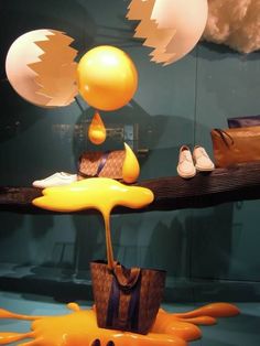 an assortment of shoes and bags on display in a store window with yellow liquid pouring down the floor