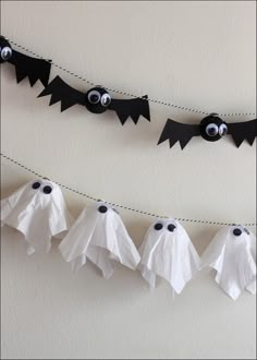 some paper bats hanging from a line with eyes on them