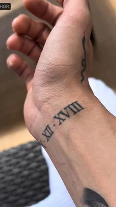 a person with a tattoo on their arm holding up the word fix written in black ink