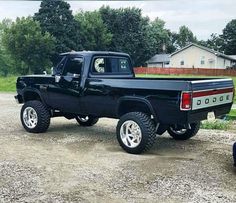 a black pickup truck parked on top of a gravel road