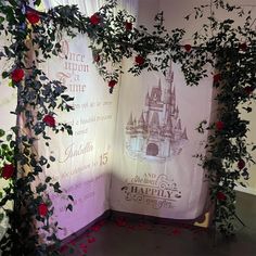 an open book with roses on it and a castle in the background is surrounded by greenery