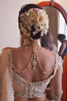 the back of a woman's dress in front of a mirror with flowers on it