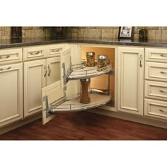 a corner shelf in the middle of a kitchen with wooden flooring and white cabinets