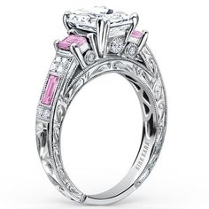 a pink and white diamond engagement ring with two stone accents on the band, set in 18k white gold