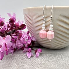 Pretty pink conch shell earrings. Made up of a larger faceted pink bead with a stack of 2 pale pink beads on top. The larger bead is darker in color and some show the striped lines of the many layers of the shell. Paired with shiny 925 sterling silver and French ear wires. All metal is solid 925 sterling silver.  Total Length of Earrings: just under 1-1/4 inches (28mm) The earrings are ready for shipping and will be shipped within 24-72 hours from purchase. They will arrive in a gift box with a Elegant Pink Earrings With Faceted Beads, Pink Faceted Earrings For Jewelry Making, Pink Faceted Drop Earrings, Pink Dangle Earrings With Faceted Beads, Elegant Pink Beaded Earrings With Faceted Beads, Pink Faceted Earrings For Gift, Pink Hypoallergenic Beaded Earrings With Round Beads, Pink Hypoallergenic Adjustable Beaded Earrings, Hypoallergenic Pink Beaded Earrings For Gift