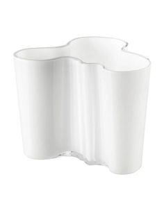 a white vase sitting on top of a white wall mounted shelf in front of a white background