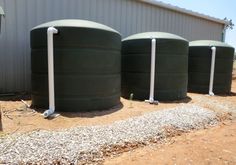 three large water tanks lined up in front of a building