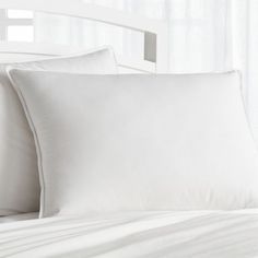 two white pillows sitting on top of a bed