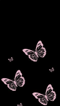 three pink butterflies flying in the dark