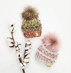 three knitted hats with pom - poms on them