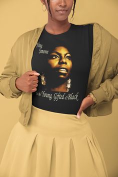 This is a High-Quality, Bella + Canvas 3001 Premium, Soft, Unisex, Short Sleeve Tee Shirt. Stylish Tee in a range of darl colors, featuring legendary Jazz, Blues, Gospel, Funk, Soul and Pop Singer and Piano player Nina Simone with the text 'To Be Young Gifted & Black'. Beautiful Art Print Tee. Ideal casual, fashionable, streetwear for any occasion. Share the Black Lives Matter message in a positive way. This updated unisex essential fits like a well-loved favorite. Super soft cotton and exce Black Music-themed Top With Letter Print, Pre-shrunk Black Music-themed T-shirt, Black Music-themed Crew Neck Top, Music-themed Black Crew Neck Top, Black Crew Neck Music-themed Top, Black Music-themed T-shirt With Letter Print, Black Music-themed Top For Concert, Fitted Music-themed Top With Crew Neck, Black Music-themed Shirt With Graphic Print