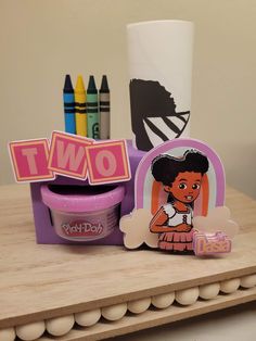 there are crayons and markers on the table next to each other, including one with an afro girl