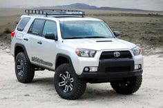 a white truck parked on top of a dirt field