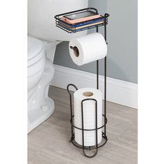 two rolls of toilet paper are stacked on a metal rack next to a white toilet