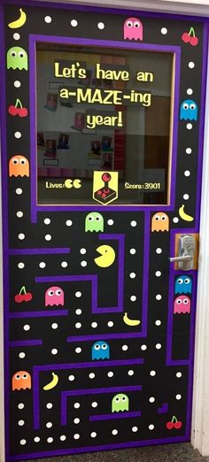 a door decorated to look like an arcade game with pacman faces and words on it