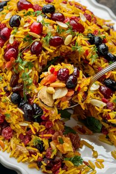 Colorful rice pilaf garnished with dried fruits, nuts, and herbs. Persian Cranberry Rice Pilaf, Jewelled Rice Persian, Persian Rice And Chicken, Jewel Rice Persian, Lebanese Hashweh Rice, Jeweled Rice Recipe, Jeweled Rice Persian, Middle Eastern Rice Dishes, Persian Dishes Recipes