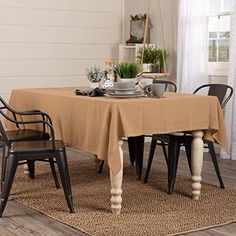 a dining room table covered with a tan tablecloth