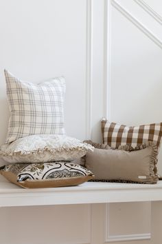 some pillows are sitting on a white shelf