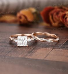 two wedding rings with a princess cut diamond in the center and side stones on each band