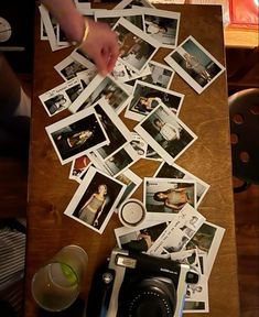 a table topped with polaroid pictures and a camera