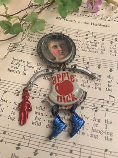 an apple jack bottle cap keychain on top of sheet music