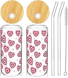 the straws are next to two glass bottles with hearts on them