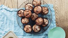 some muffins are on a wire rack next to a blue towel