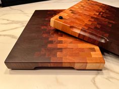 a cutting board with a knife on top of it next to another chopping board