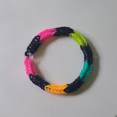 two different colored braided bracelets on a white surface