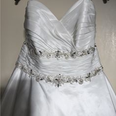 a white wedding dress hanging on a hanger