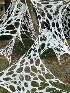 a white sculpture is in the grass near a tree