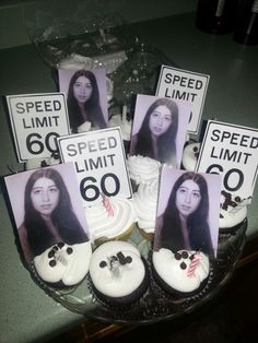 cupcakes with pictures of women and speed limit signs on them are displayed in a glass bowl