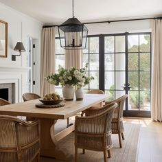 a dining room table with chairs and a bowl of fruit on top of the table