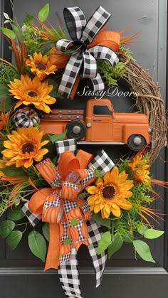 a wreath with sunflowers and an orange truck is hanging on the front door