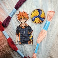 two embroidered patches, one with an image of a boy and a ball of yarn