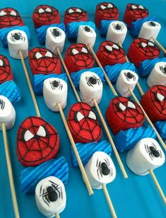 there are many spiderman marshmallows on the stick and one is white