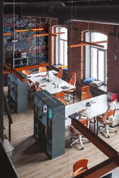 an office with desks and orange chairs