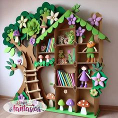 a cardboard doll house made to look like a tree with flowers and mushrooms on it