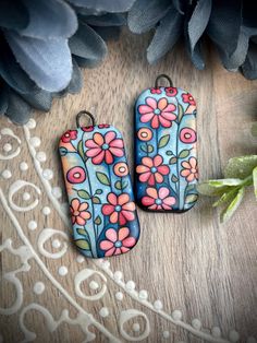 two blue and pink flowers are sitting next to each other on a wooden surface,