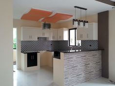 an empty kitchen with white cabinets and black counter tops in the middle of the room