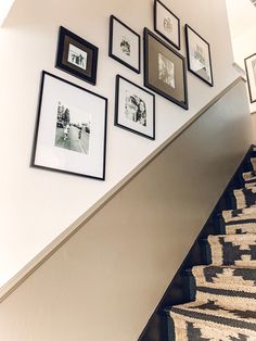 a staircase with pictures on the wall and carpeted stair treads in front of it