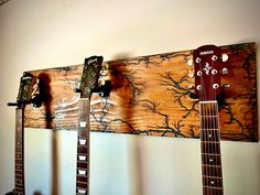 three guitars are hanging on the wall