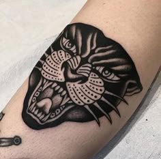 a black and white tattoo on the arm of a person with a tiger head design