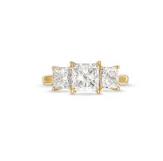 three stone diamond ring in yellow gold with diamonds on the sides and shoulders, set against a white background