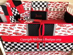 a crib bed with red and black cars on it