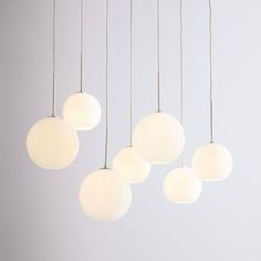 five white globe lights hanging from a ceiling