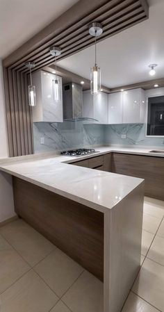 an empty kitchen with marble counter tops and cabinets