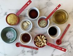 the ingredients are arranged in small bowls on the marble counter top, including cashews and nuts