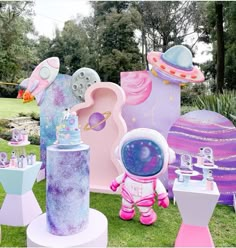 an assortment of toys and decorations on display in the grass at a children's birthday party