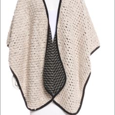 a white and black knitted shawl on a mannequin